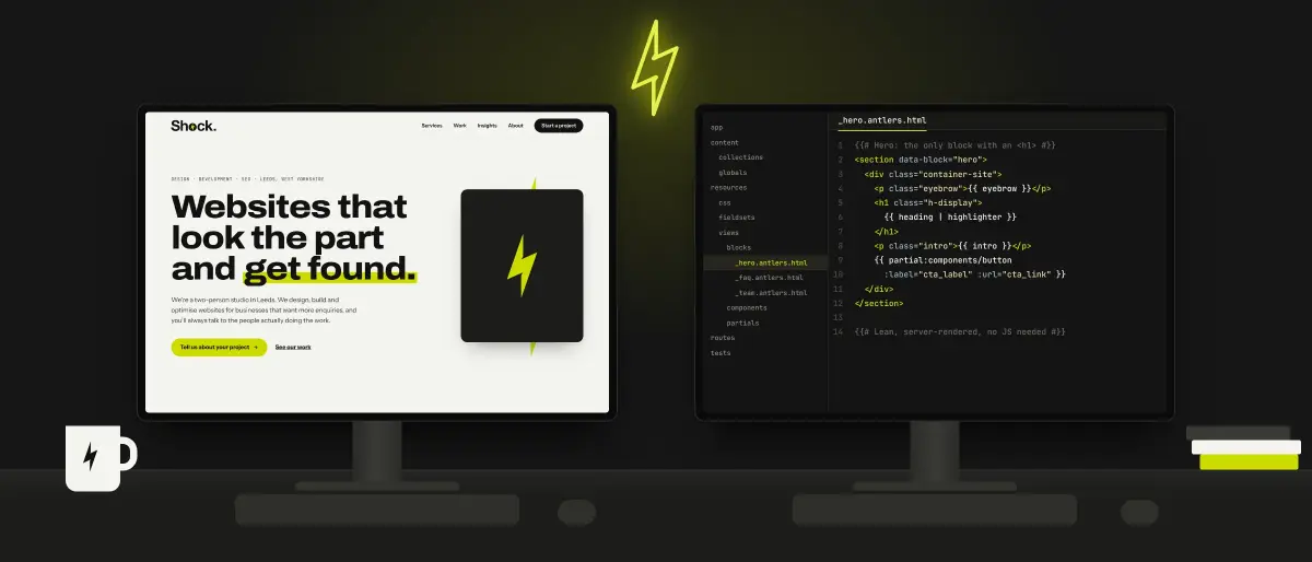 Two desks side by side, one screen showing a website design and the other the code behind it