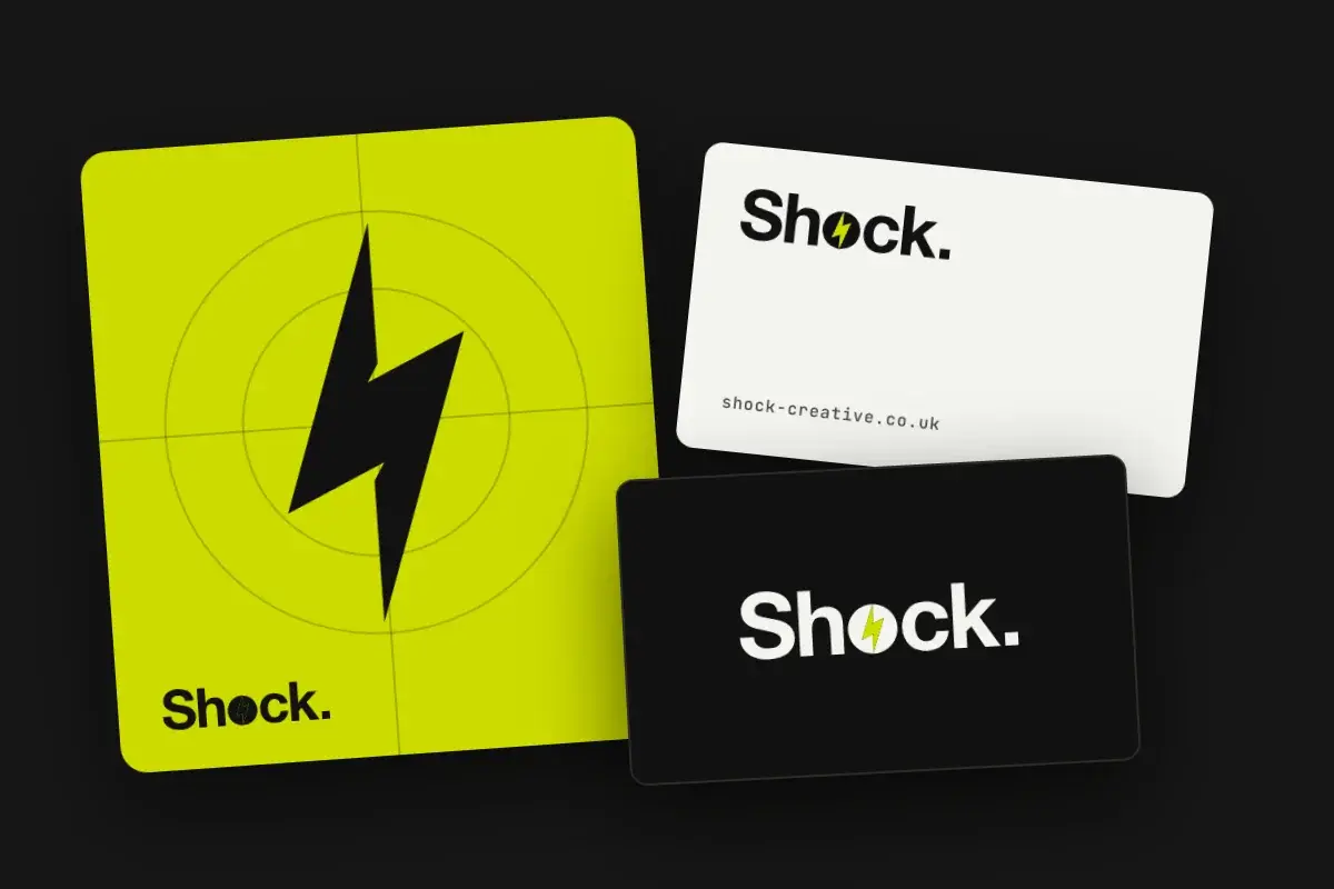 The bolt logo mark on a green tile beside Shock Creative business cards